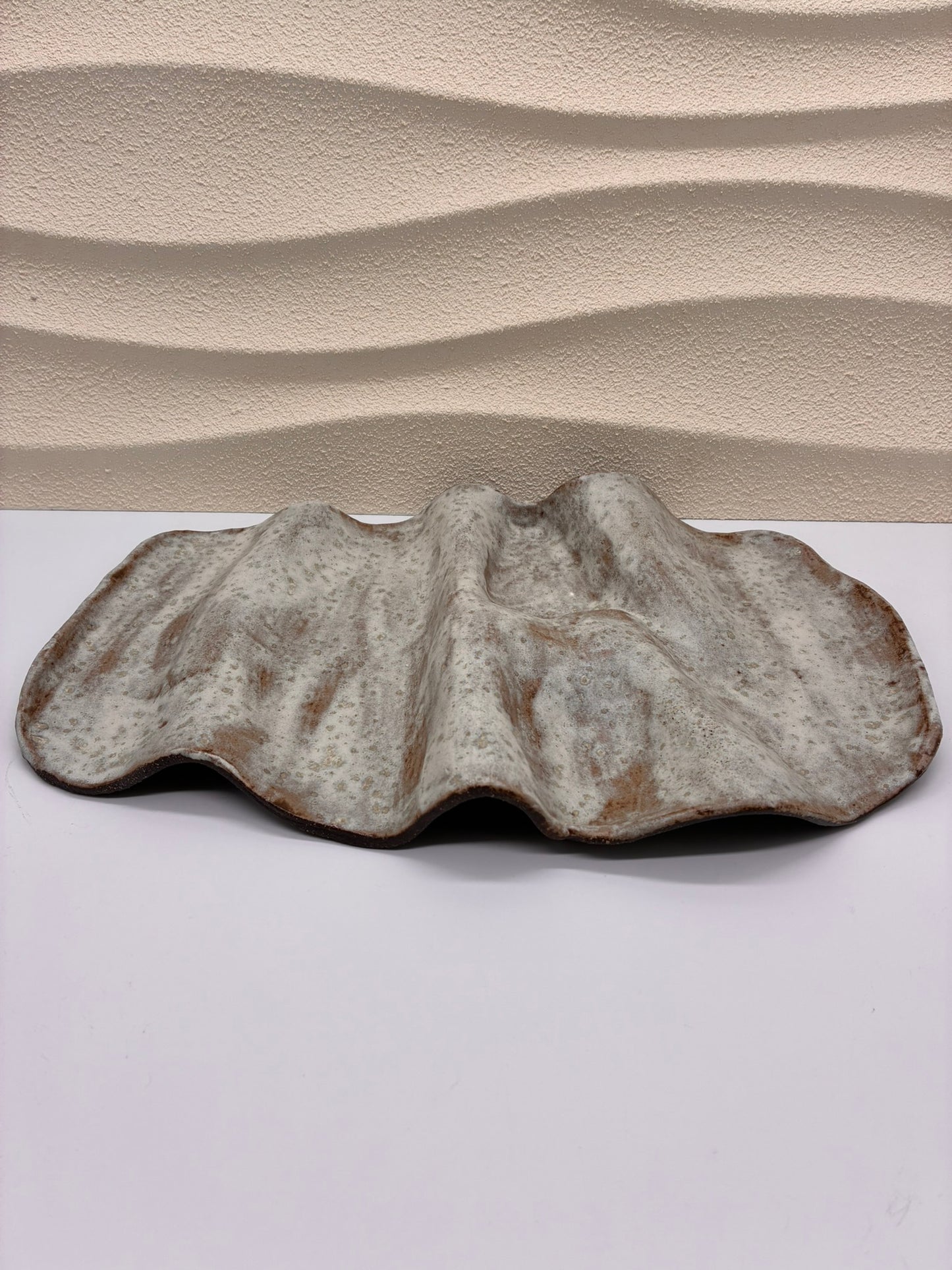 Inspired by the gentle undulations of ocean waves, the Tideform Stoneware Platter brings a natural, sculptural elegance to your table. Handcrafted with an organic, flowing form and a weathered, sea-washed glaze, it’s perfect for serving appetizers, fruit, or as a stunning centerpiece. The subtle blend of earthy tones and textured surface evokes coastal tranquility, making it both functional and artistic.