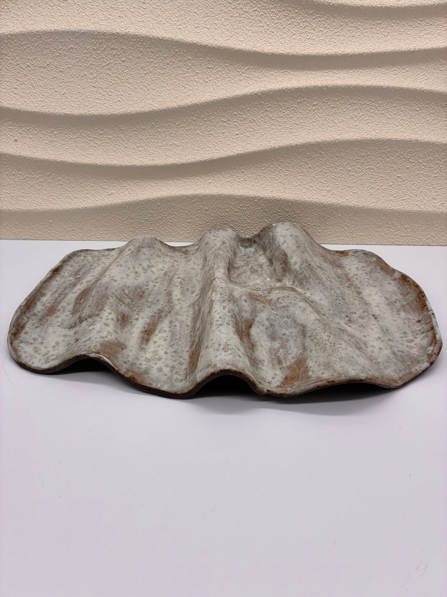 Inspired by the gentle undulations of ocean waves, the Tideform Stoneware Platter brings a natural, sculptural elegance to your table. Handcrafted with an organic, flowing form and a weathered, sea-washed glaze, it’s perfect for serving appetizers, fruit, or as a stunning centerpiece. The subtle blend of earthy tones and textured surface evokes coastal tranquility, making it both functional and artistic.