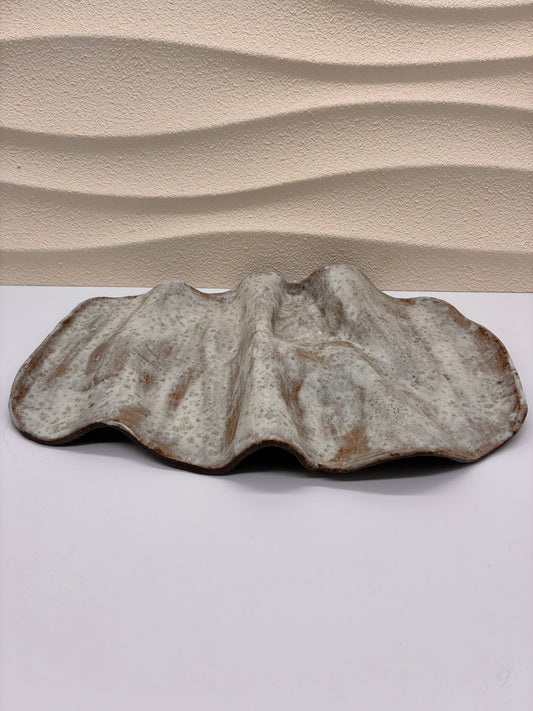 Inspired by the gentle undulations of ocean waves, the Tideform Stoneware Platter brings a natural, sculptural elegance to your table. Handcrafted with an organic, flowing form and a weathered, sea-washed glaze, it’s perfect for serving appetizers, fruit, or as a stunning centerpiece. The subtle blend of earthy tones and textured surface evokes coastal tranquility, making it both functional and artistic.