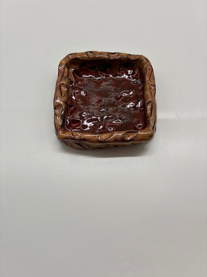This handcrafted small square dish is part of a 3-piece set, designed for both functional use and decorative display. Perfect for serving nuts, sauces, or small bites, it also doubles as a jewelry holder, making it a versatile addition to your home. Each piece is carefully made by hand, with subtle variations that highlight its artisanal character. Whether used alone or as part of the set, it combines practicality with elegant design, suitable for table service or stylish organization.