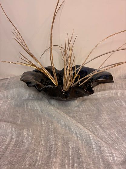 This handcrafted deep ceramic bowl features a wavy, organic form with subtle blue glaze accents, giving each piece a unique and artistic character. Perfectly versatile, it can be used as a decorative centerpiece or functionally for serving salads, fruits, or other dishes. Each bowl is individually made by hand, with natural variations in shape and glaze that celebrate its artisanal craftsmanship. Combining practicality with sculptural elegance, it brings both beauty and functionality to any table .