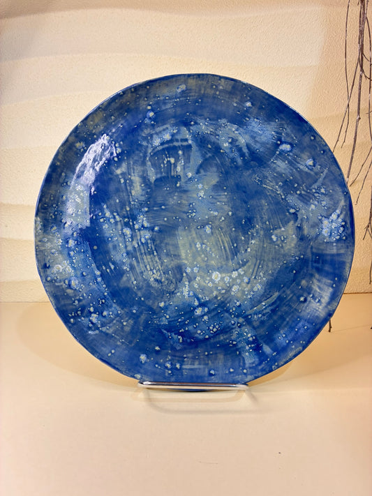 This handcrafted round plate features a blue brushstroke-inspired glaze, giving each piece a dynamic, artistic texture. Each plate is unique, with subtle variations in the glaze that reflect its artisanal craftsmanship. Designed solely for serving meals, it brings a sense of color, creativity, and elegance to any dining table.