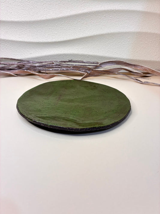 This handcrafted small ceramic plate features a rich green glaze, creating a vibrant yet natural look. Perfect for serving appetizers, small dishes, or desserts, it combines functional use with refined design, adding a touch of elegance to any table setting.