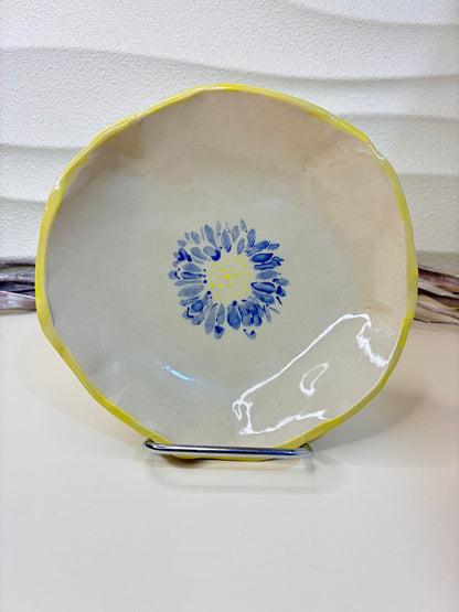 This handcrafted ceramic bowl features a hand-painted blue floral  on the interior, adding a delicate artistic touch to its timeless form. Each piece is individually made and painted by hand, resulting in subtle variations that make every bowl unique. Both functional and decorative, it is ideal for everyday use while bringing a refined, artisanal accent to the table.
