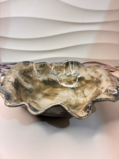 Inspired by the gentle movement of water across clay, the&nbsp;&nbsp;Ripple Salad Bowl captures the harmony between nature and form. Each curve is hand-shaped, giving the rim its distinctive wave-like pattern. Glazed in warm earthy tones with a natural sheen, this bowl brings a touch of rustic elegance to your dining table — perfect for serving fresh salads, fruits, or as a centerpiece that celebrates the beauty of handmade craftsmanship.