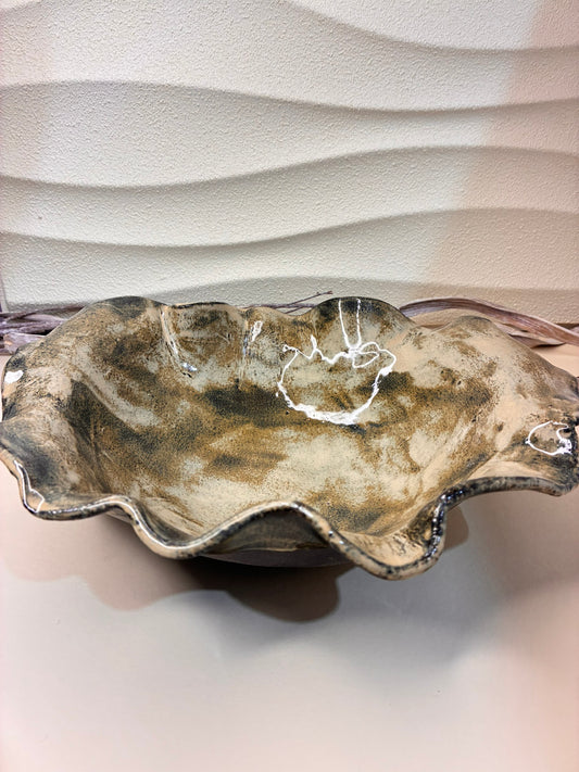 Inspired by the gentle movement of water across clay, the&nbsp;&nbsp;Ripple Salad Bowl captures the harmony between nature and form. Each curve is hand-shaped, giving the rim its distinctive wave-like pattern. Glazed in warm earthy tones with a natural sheen, this bowl brings a touch of rustic elegance to your dining table — perfect for serving fresh salads, fruits, or as a centerpiece that celebrates the beauty of handmade craftsmanship.