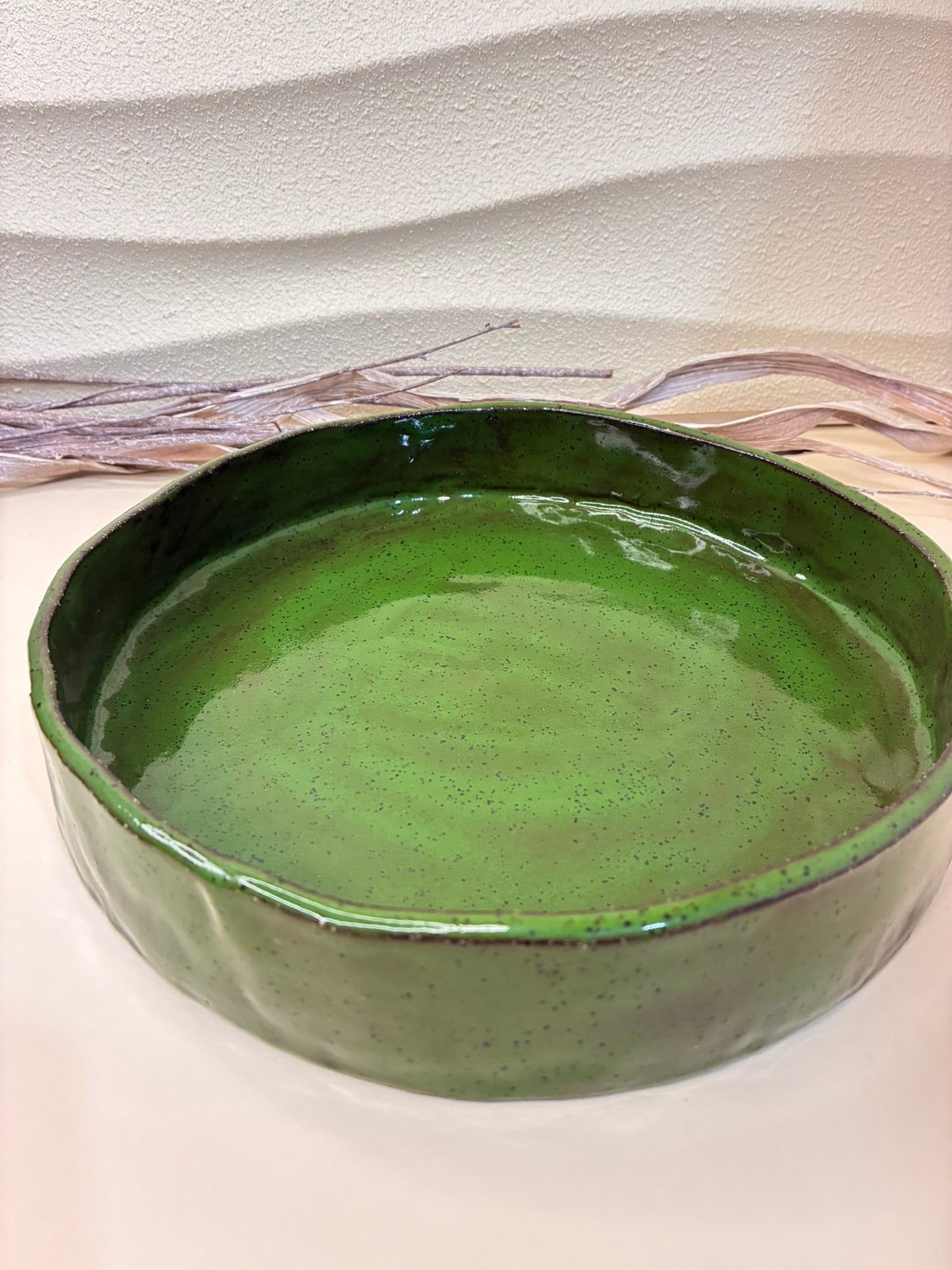 This handcrafted green ceramic bowl,  is a part of a coordinated tableware set. It is designed for everyday use and versatile serving. Ideal for salads, pasta, or snacks, it combines functionality with a refined, timeless aesthetic. Each bowl is individually made by hand, with subtle variations that highlight its artisanal character and natural glaze.