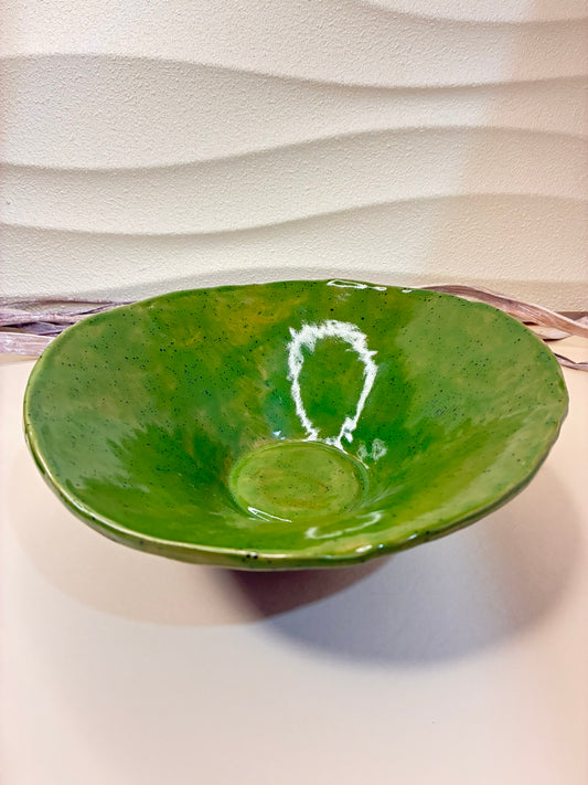 The Verdant Wave Bowl embodies the serene beauty of nature through its flowing form and rich green glaze. Handcrafted with subtle curves and a glossy finish, it reflects light like ripples on a calm forest pond. The deep emerald tones evoke renewal and balance, making it a striking accent piece for modern or rustic interiors alike.

Details:

Material: Stoneware clay

Finish: Glossy green glaze over dark clay

Handmade — unique variations in color and texture

Ideal for serving, plating, or decorative use.