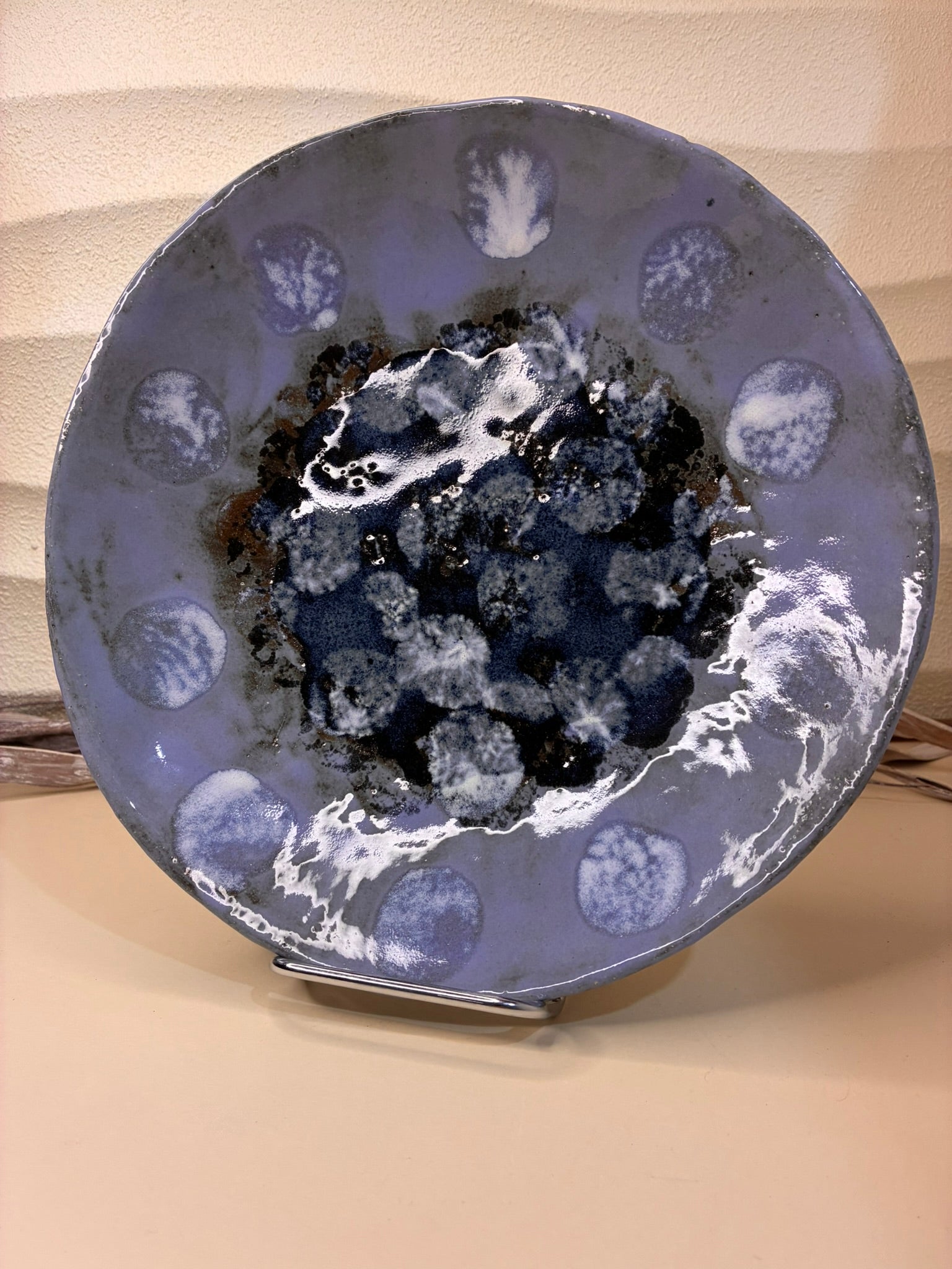 This handcrafted deep round plate features a blue glaze inspired by the Frozen Dot technique, creating a speckled, textured effect reminiscent of frost or delicate droplets. Perfect for serving meals or as a decorative platter, each piece is unique, showcasing subtle variations that highlight its artisanal craftsmanship. Combining functionality with artistic elegance, it adds a touch of sophistication to any table or display.