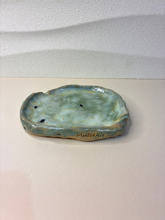 This handcrafted shallow tray serves as a discreet ashtray while also doubling as a jewelry holder. Its minimalist design and subtle, elegant form make it a versatile addition to any table, dresser, or shelf. Each piece is carefully handmade, with unique variations that highlight its artisanal character, combining functionality and refined style in one.