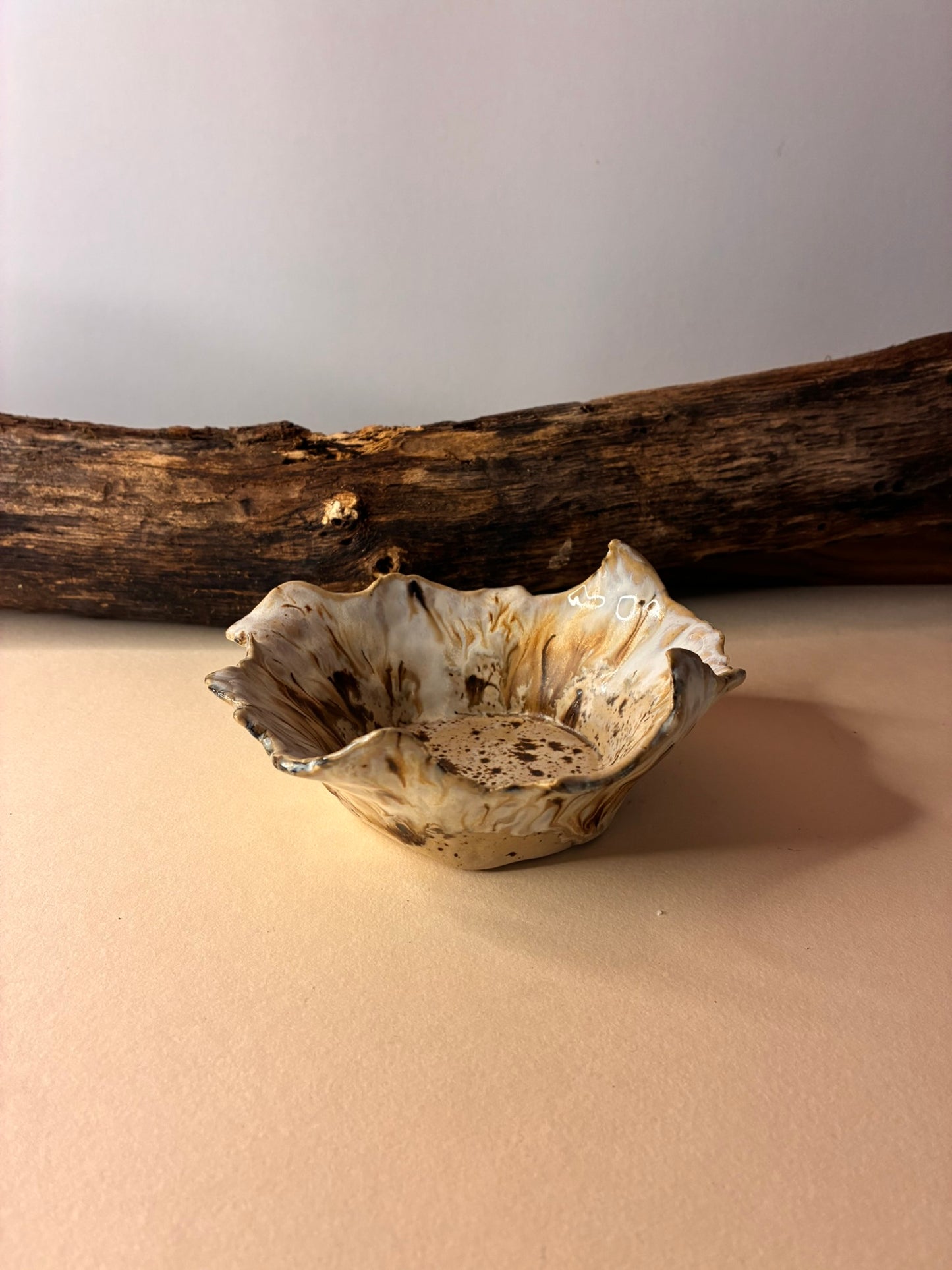 This handmade ceramic bowl echoes the natural curves of a seashell shaped by water and time. Its raw texture and soft, neutral glaze make it a timeless accent for any space. Ideal for holding small objects , snacks  or simply standing alone as a sculptural piece.